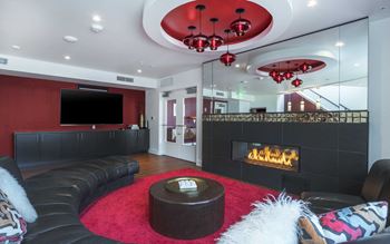 resident social lounge with a black leather couch and a fireplace